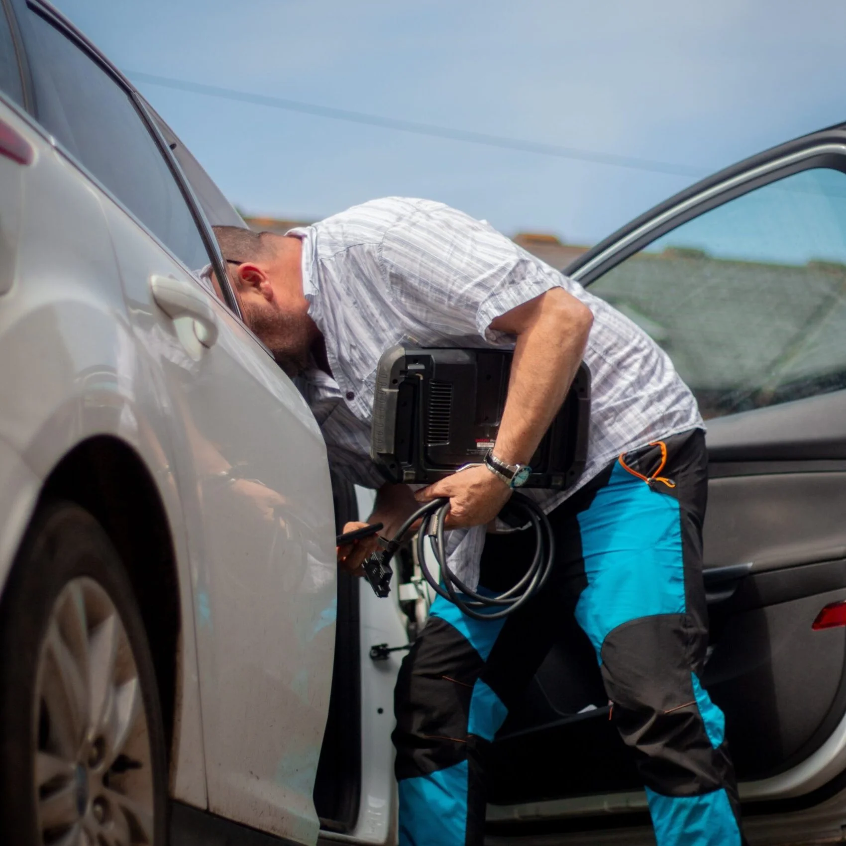 Automotive locksmith working on a vehicle
